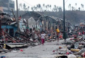 Residents walk past damaged structures caused by typhoon Haiyan,  in Tacloban city, Leyte province central Philippines on Sunday, Nov. 10, 2013. Haiyan, one of the most powerful typhoons ever recorded, slammed into central Philippine provinces Friday leaving a wide swath of destruction and scores of people dead.  (AP Photo/Aaron Favila)