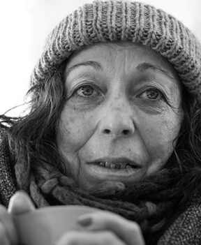 An elderly homeless woman with a cup of soup , social problems like homelessness problem concept 